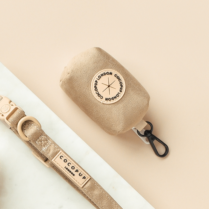 Nude-colored Cocopup London poop bag holder with aviator-style design and black clip.