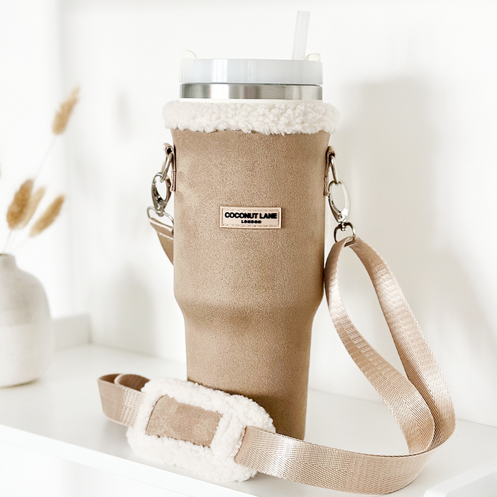 Nude tumbler carry case with fuzzy trim, cross-body strap, and stainless steel cup by Cocopup London.