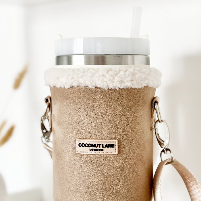 Nude tumbler carry case with sherpa trim, cross-body strap, and Cocopup London logo detailing.