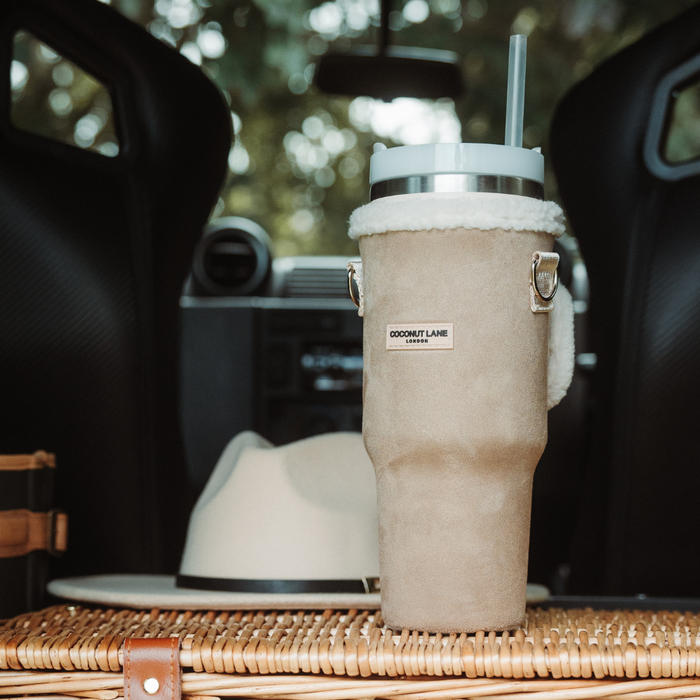 Cocopup London Nude Aviator tumbler carry case with suede sleeve and sherpa trim in a car cup holder.