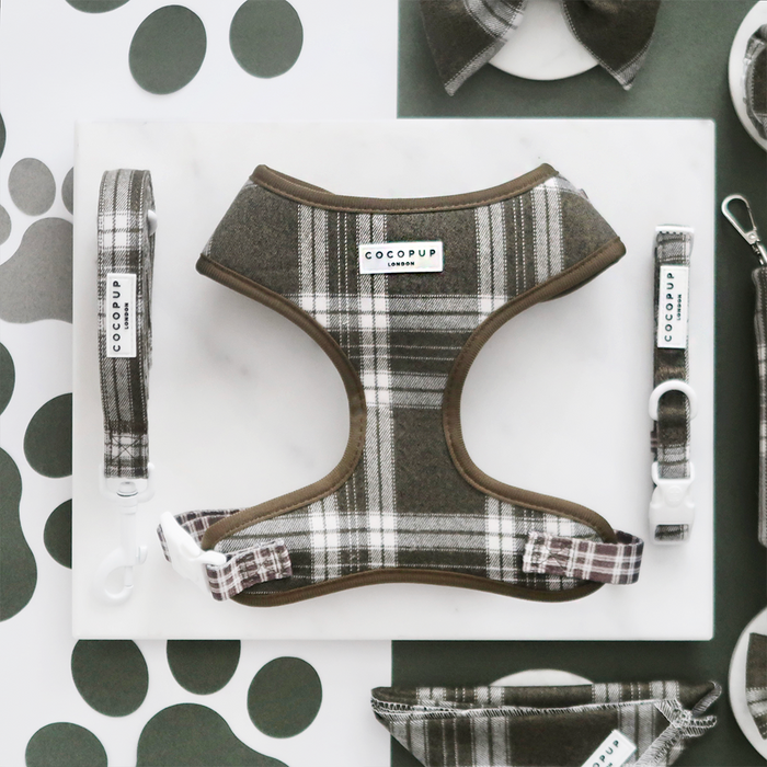 Olive check harness, lead, and collar set from Cocopup London on a white surface with scattered paw prints.