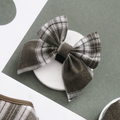 Olive green and white check sailor bow tie from Cocopup London, displayed on a green and white background.