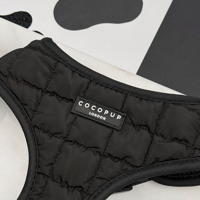 Onyx quilted adjustable neck harness in black by Cocopup London, shown close-up against a black and white background.