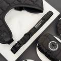 Black quilted dog collar with matching accessories from Cocopup London on a white marble background.
