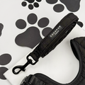 Black quilted Cocopup London dog lead for small breeds, displayed on a white background with black paw prints.