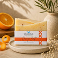 Bar of soap with 'OldSoul Soap Company' packaging on a plate with oranges and a vase in the background