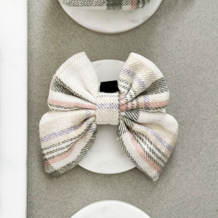 Plaid sailor bow tie with pink, purple and green stripes on a gray background.