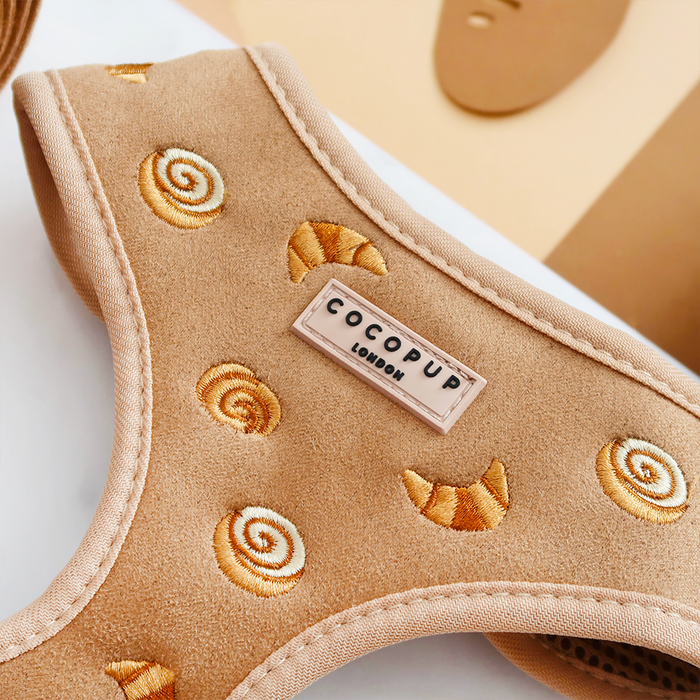 Tan adjustable dog harness with croissant embroidery detailing.