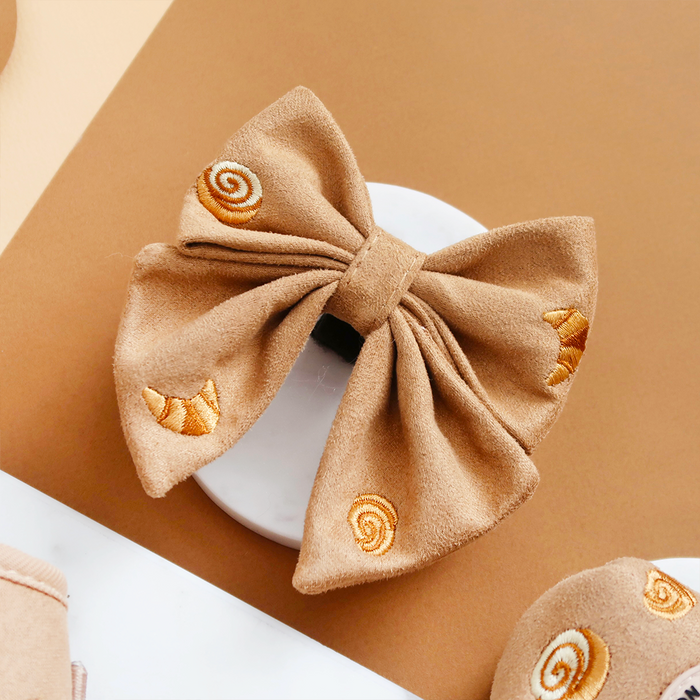 Tan sailor bow tie with yellow snail and croissant pattern, from Cocopup London.