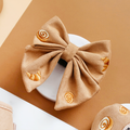 Tan sailor bow tie with yellow snail and croissant pattern, from Cocopup London.