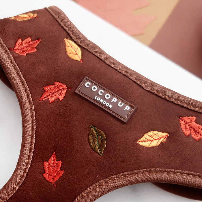 Adjustable dog harness with safety lock, featuring embroidered autumn leaves and neutral-toned straps.