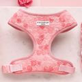 Peony Pup pink harness, lead, and collar set by Cocopup London on marble surface with a pink flower beside it.