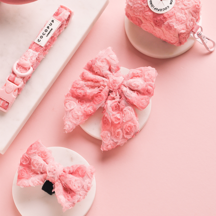 Pink textured Cocopup London Peony Pup Bow Tie shown on marble and pink backgrounds.