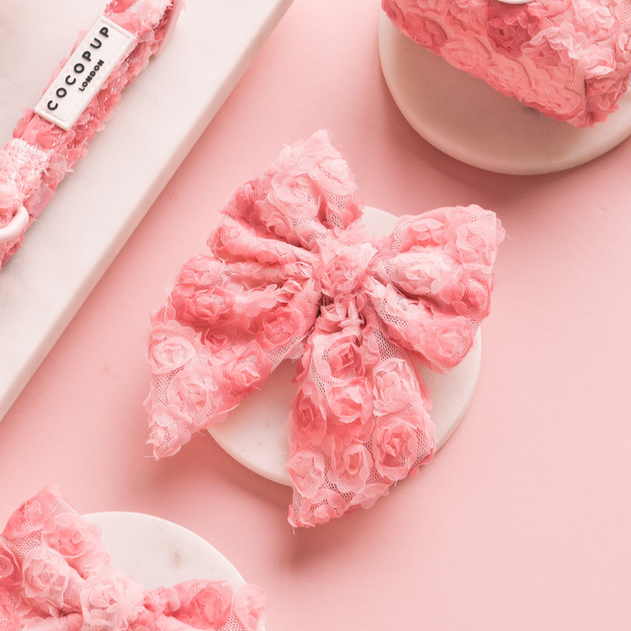 Peony Pup Sailor Bow Tie by Cocopup London, pink floral fabric, displayed on a marble coaster with a pastel background.