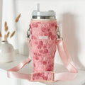 Peony Pup Tumbler Carry Case with pink floral pattern on a white shelf next to a neutral dried flower vase.