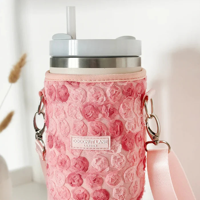 Pink carry case with matching strap, silver tumbler, clear straw, and lid from Cocopup London’s Peony Pup collection.