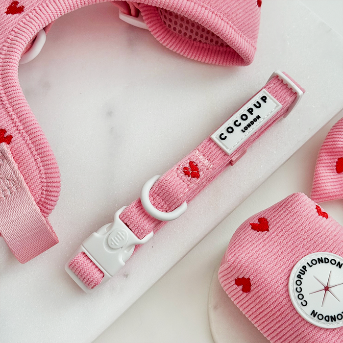 Pink cord bundle featuring an adjustable neck harness, lead, and collar with a small red heart pattern.