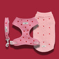 Pink cable knit dog jumper, harness, and lead set with red heart pattern from Cocopup London.