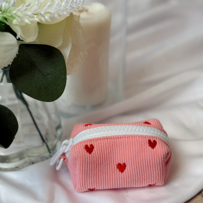 Pink corduroy poop bag holder with red heart pattern, from Cocopup London.