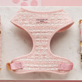 Pink textured tweed dog harness with gold buckles, adjustable neck, by Cocopup London on a marble surface.