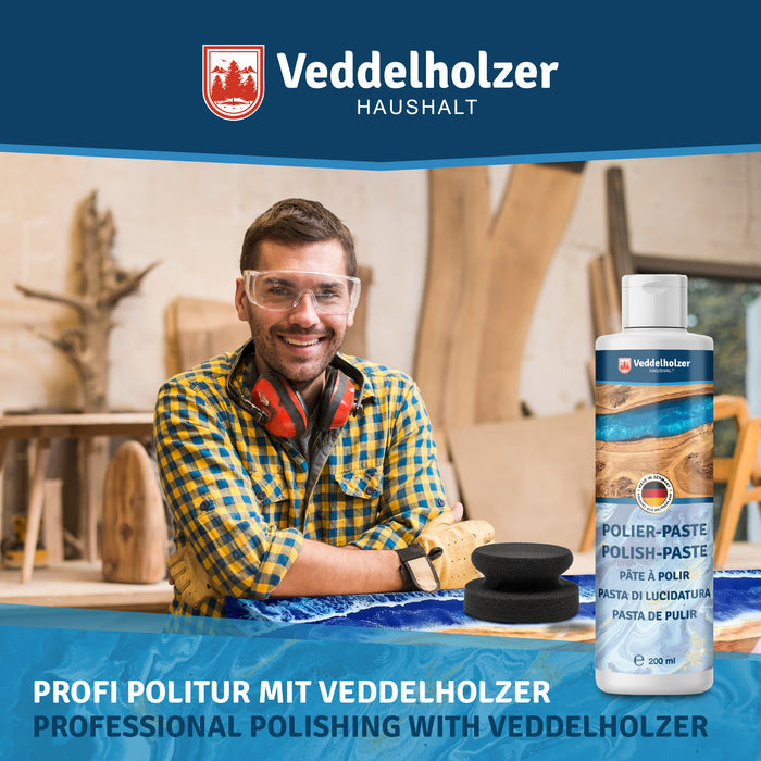 Handwerker mit Schutzbrille und Gehörschutz an einem Epoxidharztisch in der Werkstatt, daneben Flasche und Polierpuck