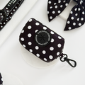 Polka dot poop bag holder with round Cocopup London label and metal clip.