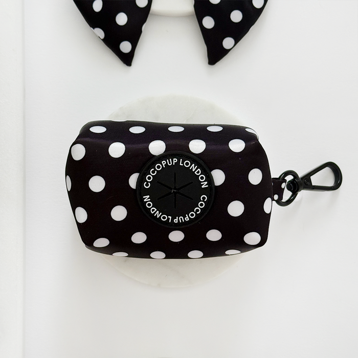 Cocopup London poop bag holder in beige with black polka dots, metal clip, and small branded badge.