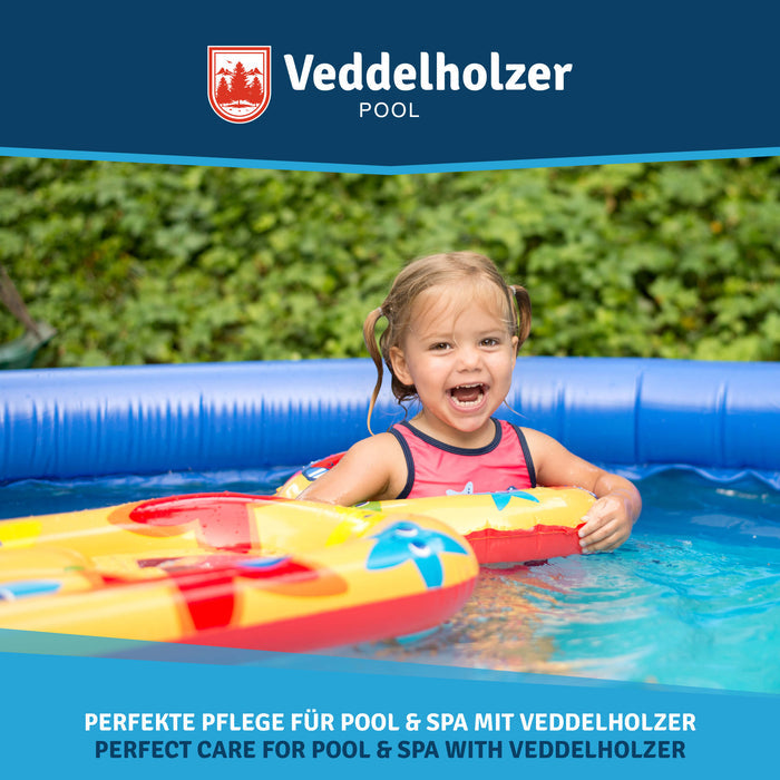 Lachendes Mädchen mit Zöpfen sitzt mit einem gelb-roten Schwimmreifen im blauen Planschbecken