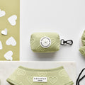 Light green poop bag holder with white heart cutouts, Luxe Poop Bag Holder - Sage Heart by Cocopup London.