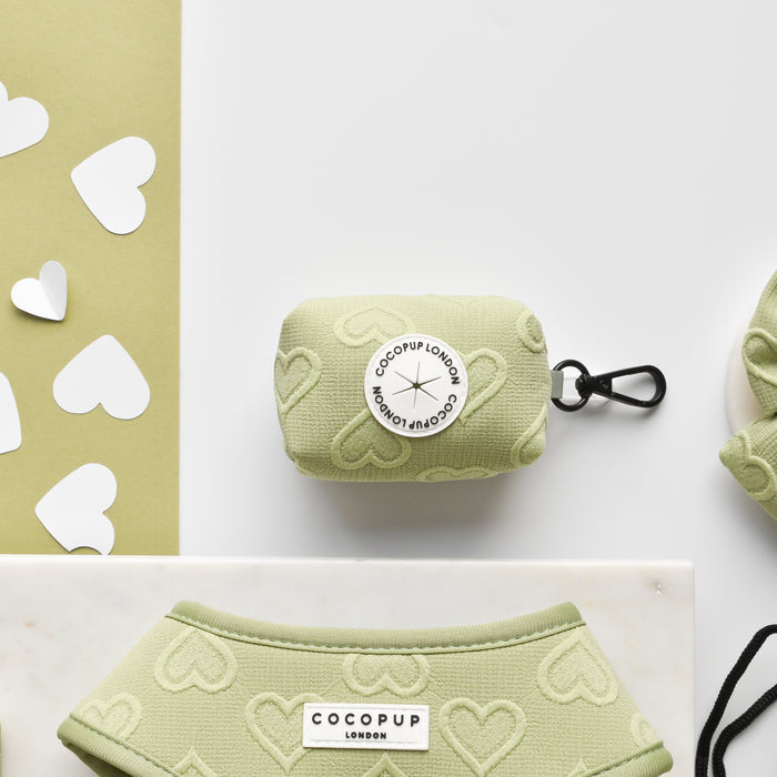 Light green poop bag holder with white heart cutouts, Luxe Poop Bag Holder - Sage Heart by Cocopup London.