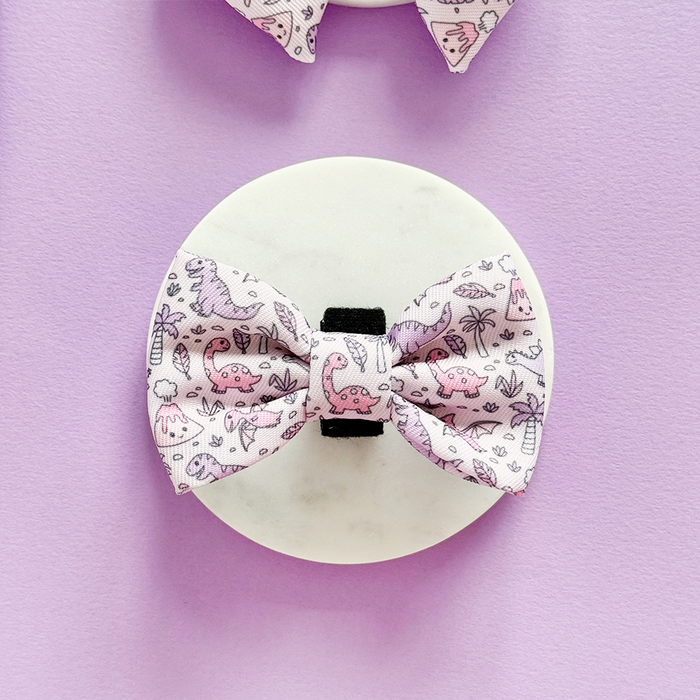 Pink and purple dog bow tie with playful dinosaur print from Cocopup London.