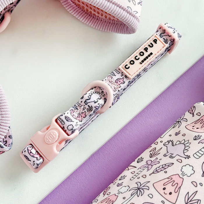 Pink harness, lead, and collar set with cartoon dinosaur pattern from Cocopup London.