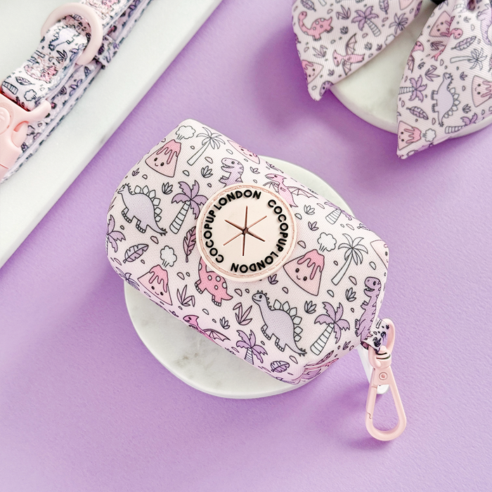 Pink poop bag holder with cute dinosaur print and gold clip by Cocopup London.