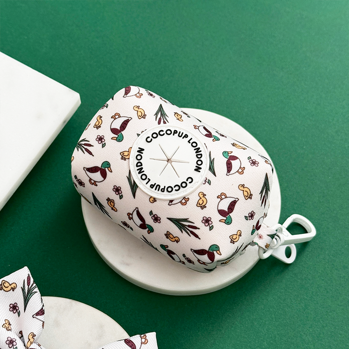 Cocopup London Puddle Pup Poop Bag Holder on a round tray, shown with a green background.