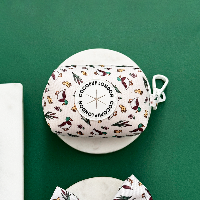 White neoprene poop bag holder with a yellow duck pattern from Cocopup London.
