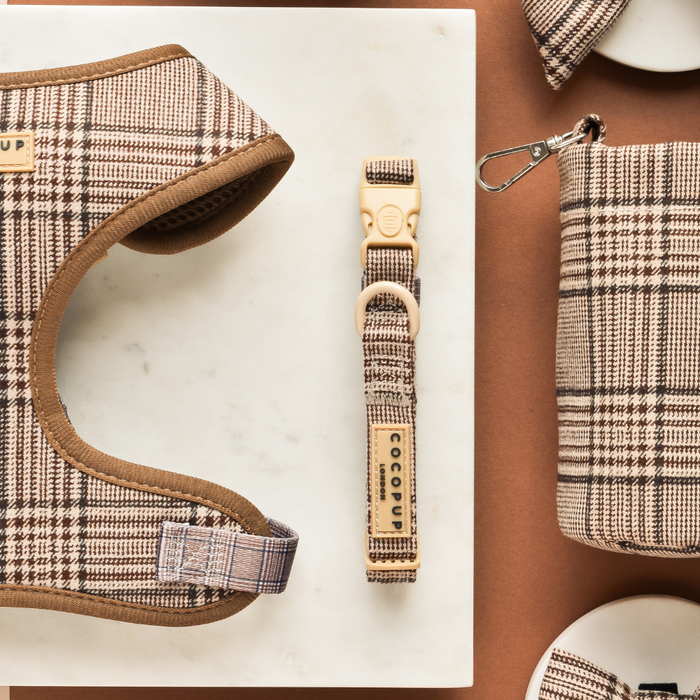 Plaid collar, leash, and pouch set from Cocopup London on a marble and brown surface.