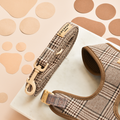 Plaid dog lead with tan and brown pattern, displayed on marble with matching paper cutouts in the background.