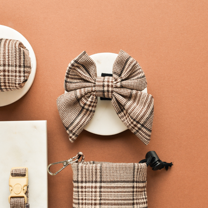 Pup Plaid Sailor Bow Tie by Cocopup London in plaid pattern, shown with matching tan plaid accessories on a white surface.