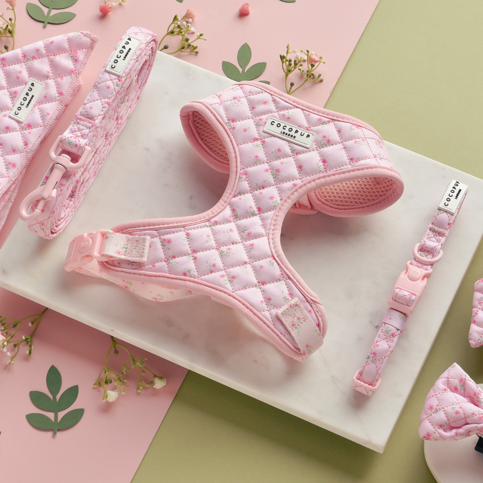 Pink quilted floral harness, lead, and collar set from Cocopup London displayed on a pastel background.
