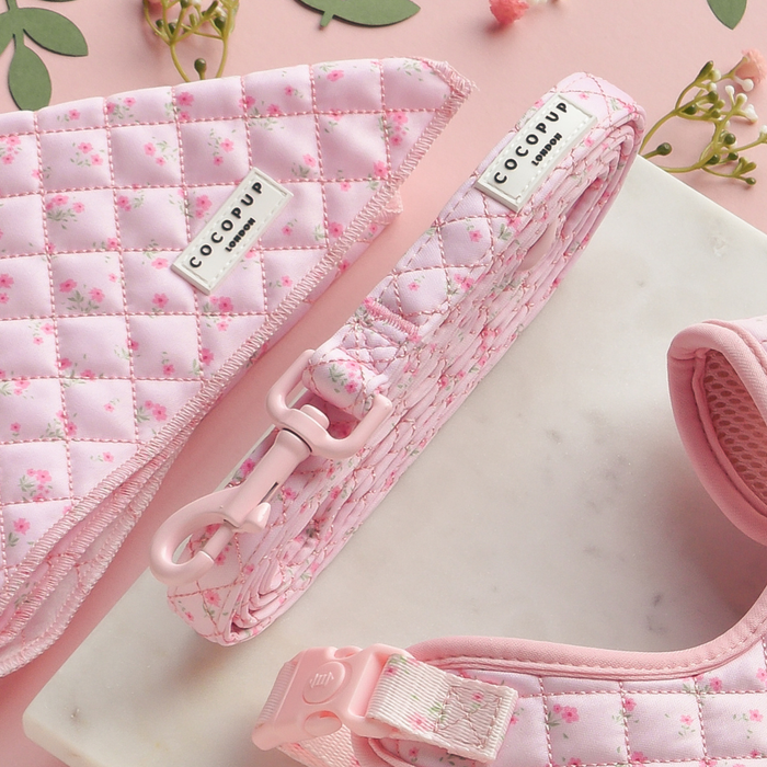 Quilted pink floral dog lead from Cocopup London on a marble and pink background.