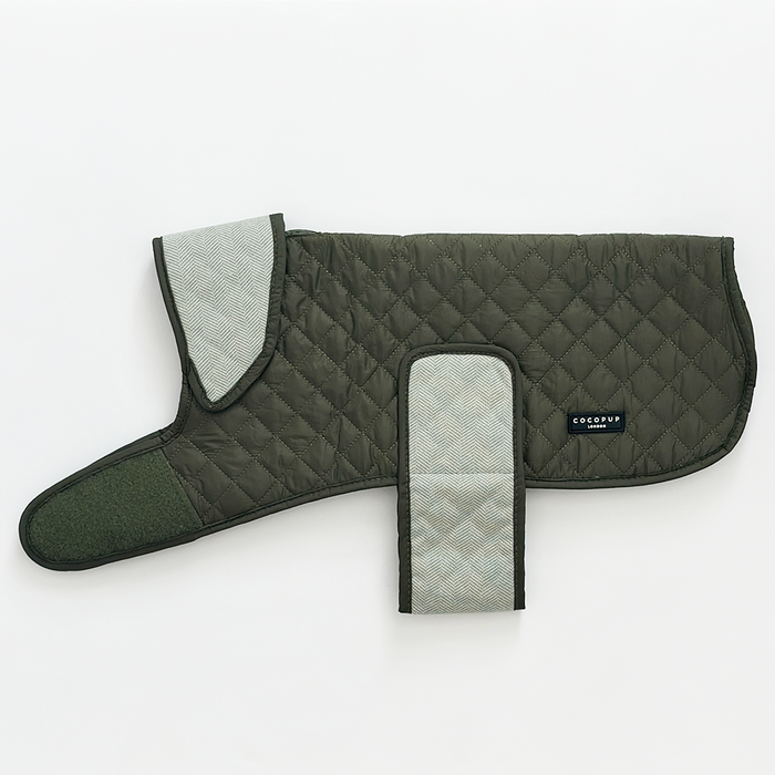 Quilted dog coat in country khaki with light gray lining and velcro straps, displayed on a white background.