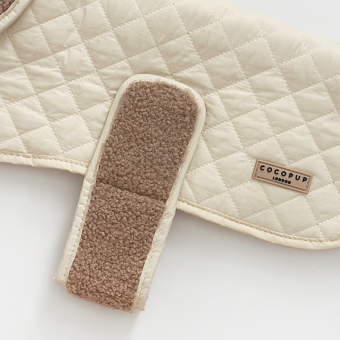 Cream quilted dog coat with soft brown fleece strap and Cocopup London rectangular patch.