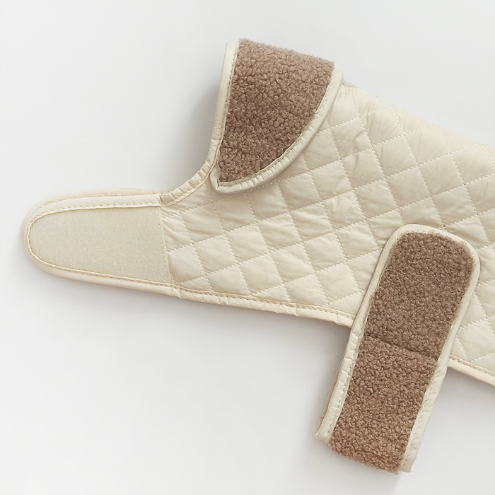 Creamy chai quilted dog coat with Velcro straps and soft teddy lining, laid flat on a white background.
