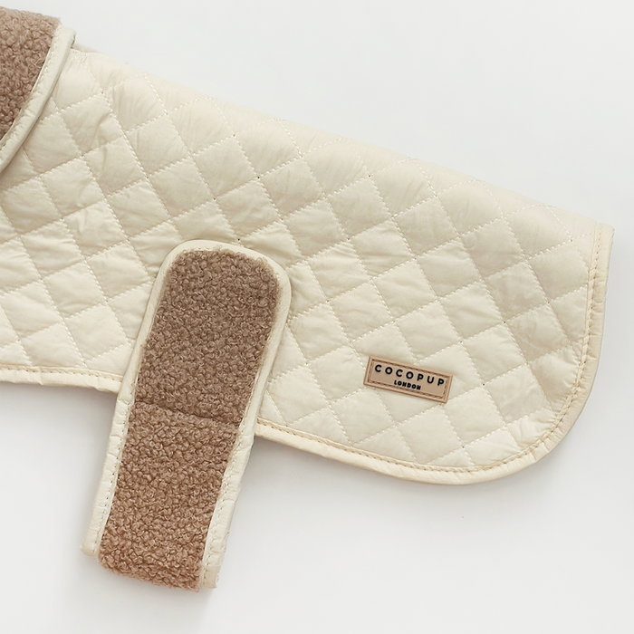Cream Chai quilted dog coat with teddy lining and Cocopup London label on a white background.