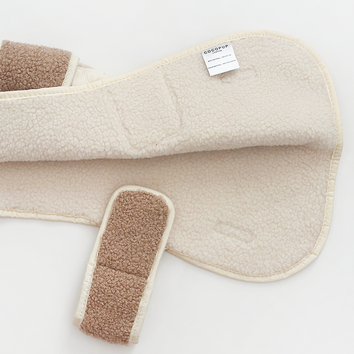 Creamy chai quilted dog coat with Velcro strap, laid flat on a white background.