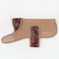 Tan quilted dog coat with leopard print collar and strap, displayed flat on a white background.