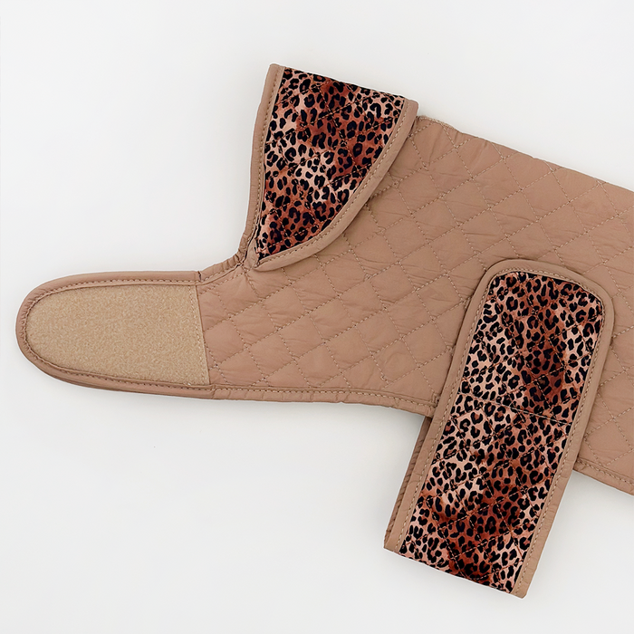 Tan quilted dog coat with brown leopard print trim and hook-and-loop fasteners.
