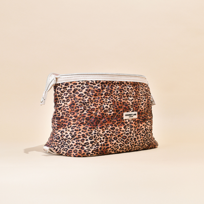 Expandable quilted makeup bag with a leopard print, zip closure, and a small white label on the front.