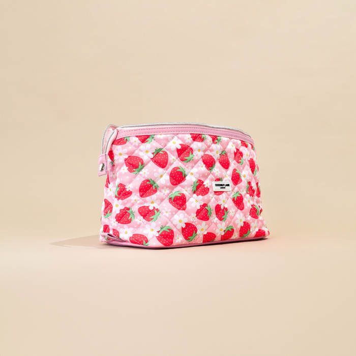 Quilted expandable makeup bag with red strawberry and white daisy print on light background, by Cocopup London.