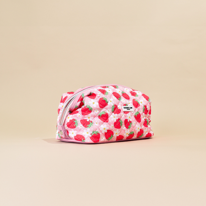 Quilted expandable makeup bag with a playful berry and paw print pattern, Cocopup London branding visible.